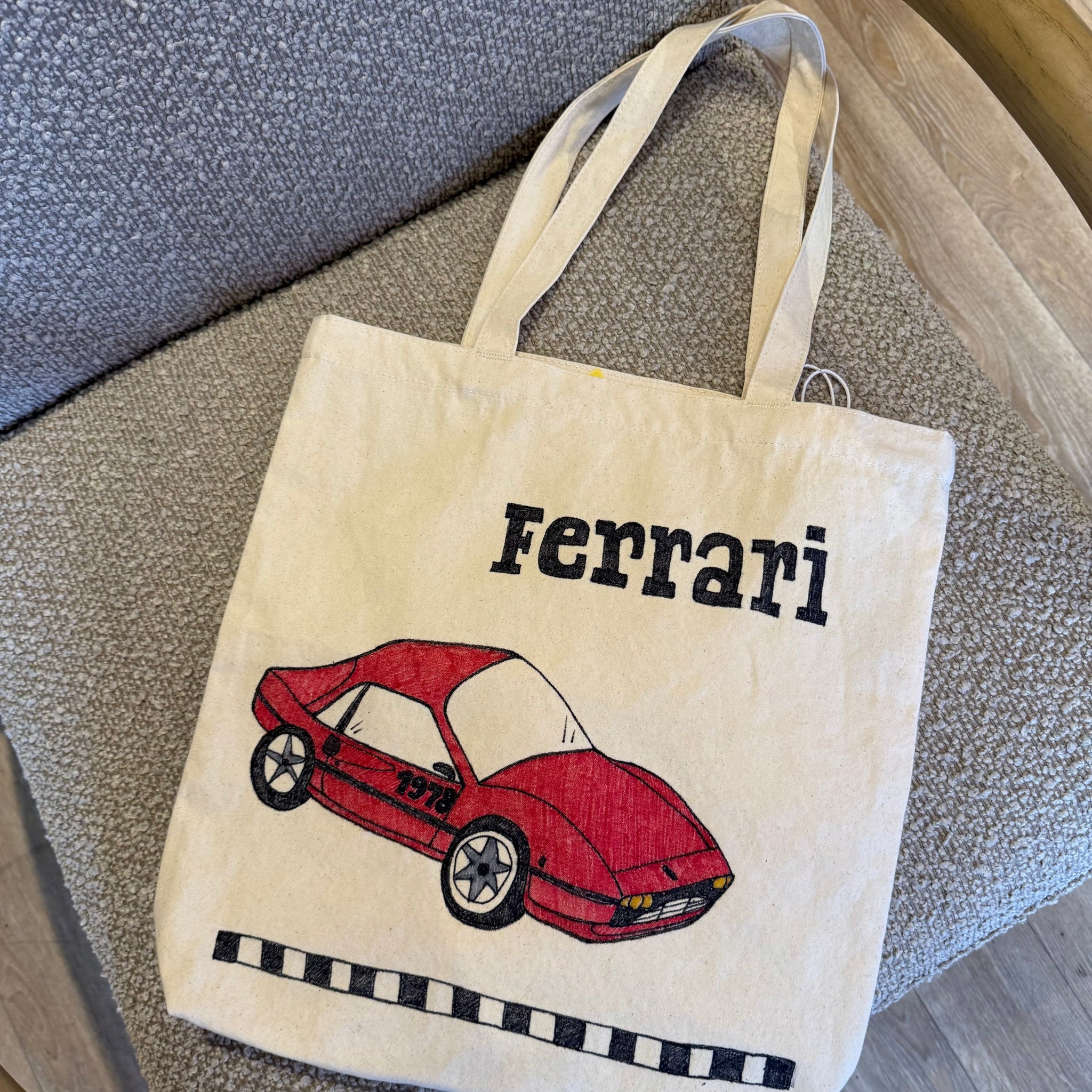 Tote bag with Ferrari logo and red car on a textured surface