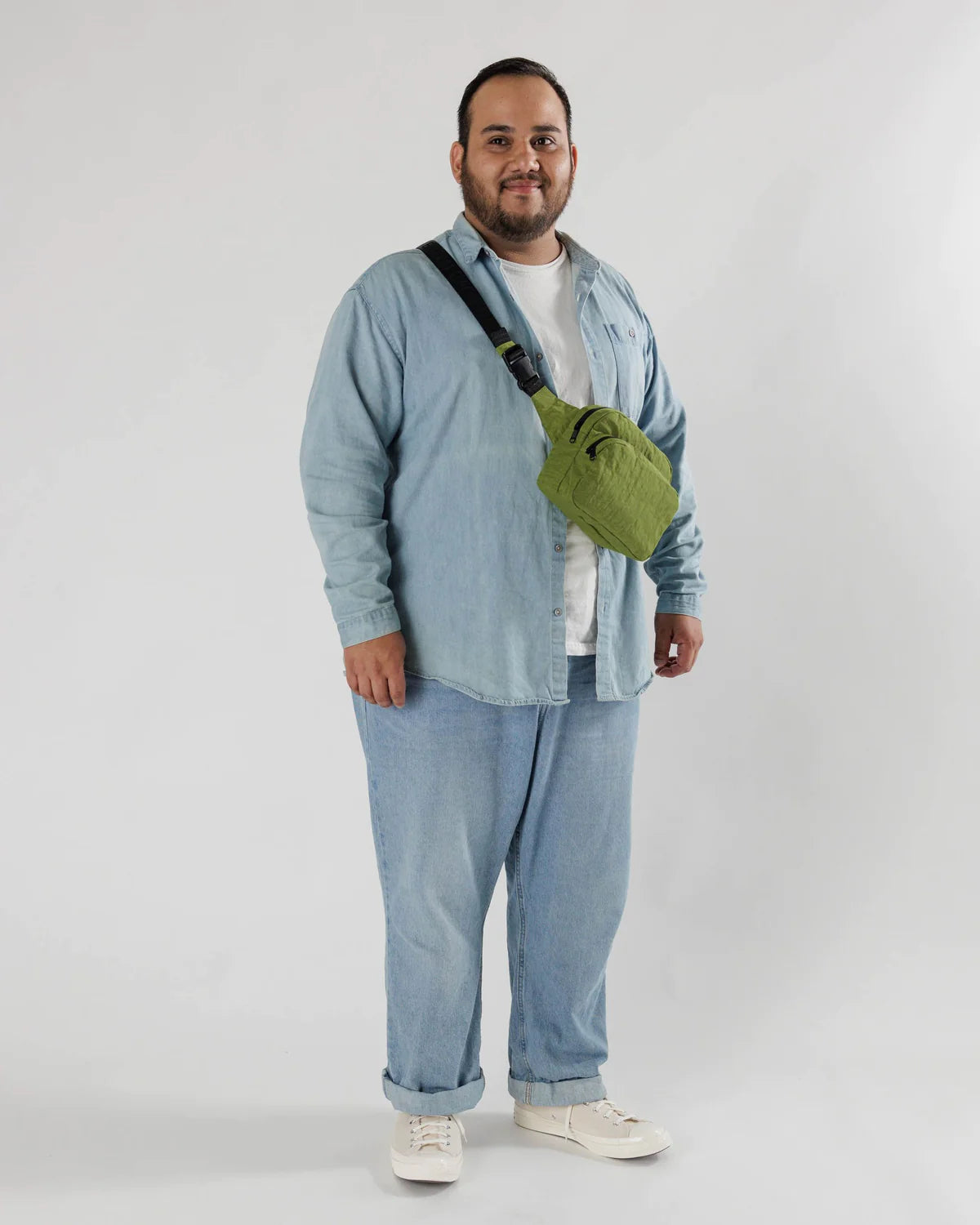 Person wearing all denim with a green Baggu shoulder bag.
