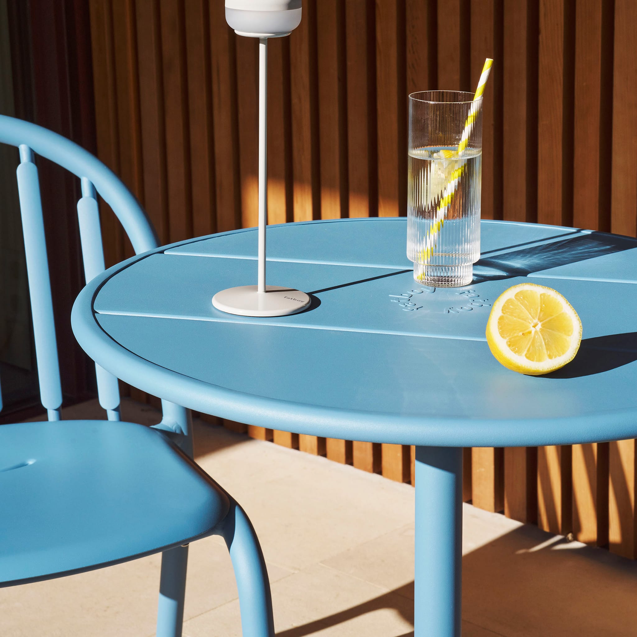 Fred’s Bistreau table with a coffee cup and book, perfect for creating a cozy outdoor retreat.