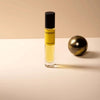 Paraphrase travel-size perfume bottle with yellow liquid, black cap, clear bottom