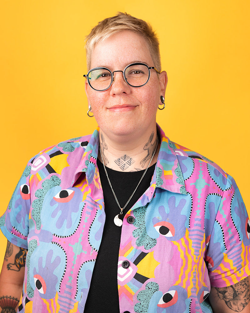 Portrait of Jo against a yellow background.
