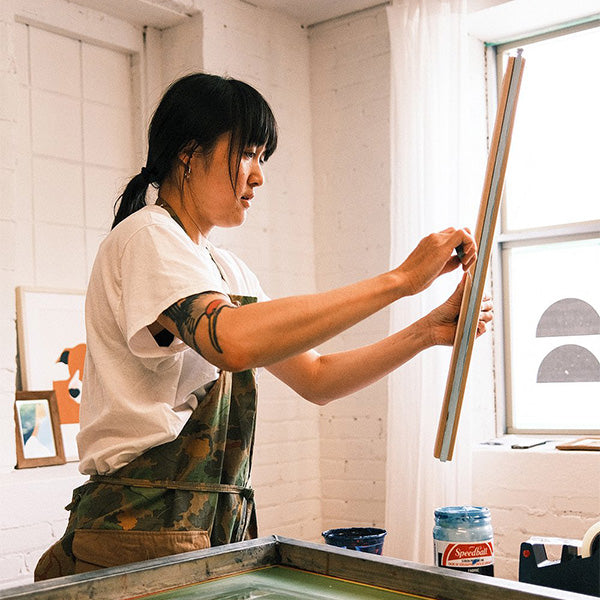 Stephanie Cheng in a print studio creating a screen print.