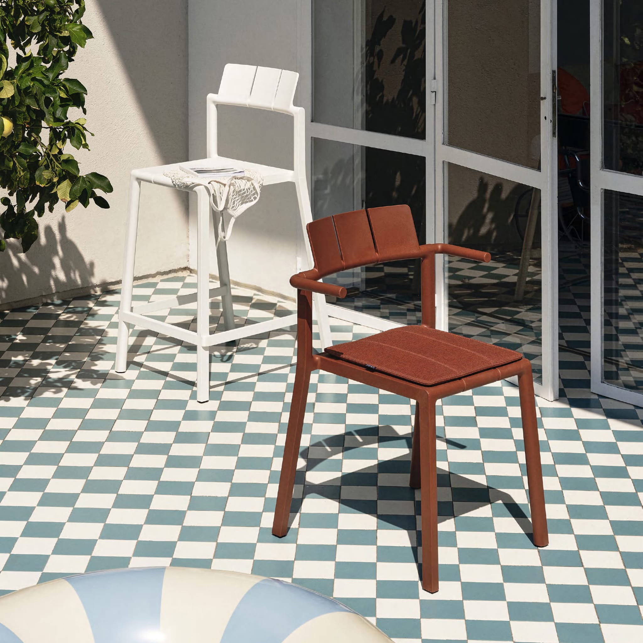 Yard armchair by TOOU Design in a modern patio setup, showcasing its ergonomic design and durable polypropylene material.