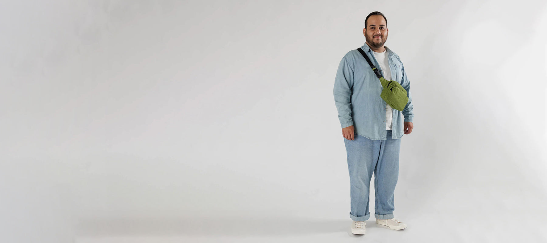 Person wearing all denim with a green Baggu shoulder bag.
